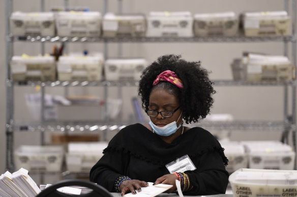 An election official handles ballots during the vote audit in Marietta, Georgia.