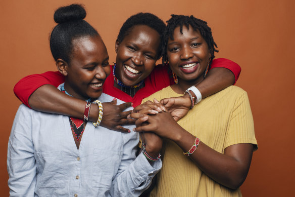Dr Kakenya Ntaiya, in red, is the first Maasai woman to go to university in the US, pictured with two university students Peyian Kortom (in yellow) and Sharon Tiyo (blue). 