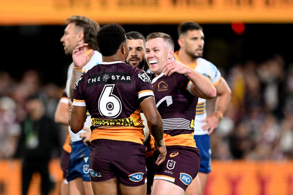 Billy Walters celebrates his try against Parramatta at the Gabba with Adam Reynolds and Ezra Mam in round 24.
