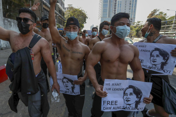 A group of shirtless demonstrator hold images of ousted Myanmar leader Aung San Suu Kyi during a protest in Yangon, Myanmar, on Wednesday.