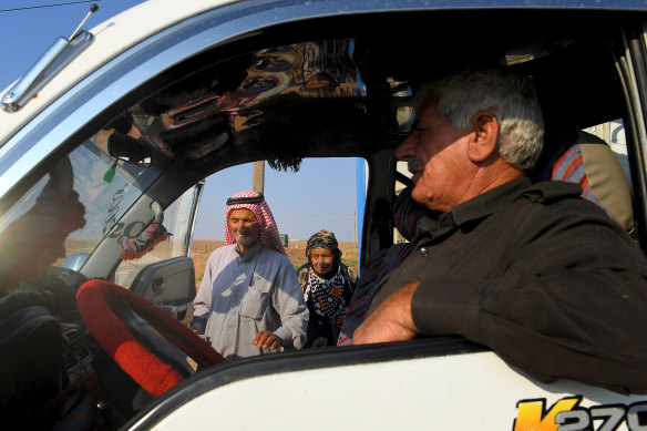 Taha Okan, 73, and his wife Aisha, 67, climb into a van destined for Hasakah. 