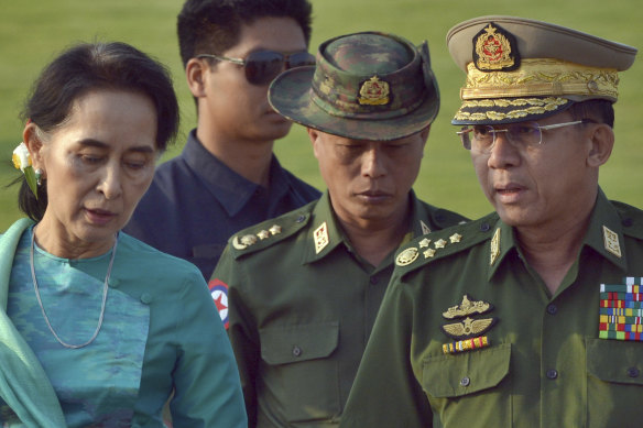 Aung San Suu Kyi (left) who has been detained in the coup, walks with General Min Aung Hlaing (right) in 2016.
