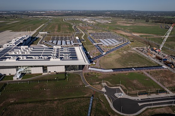 Western Sydney Airport’s terminal is several hundred metres from the site of a metro station for the airport line, which has cranes towering above it.