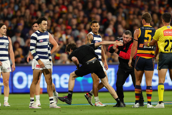 A security worker gets a hold of the Adelaide Oval pitch invader. 