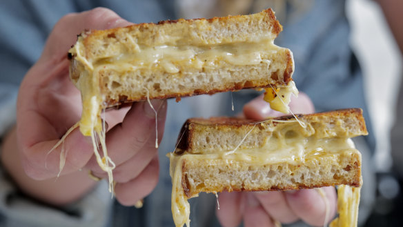 Ellie Studd holding a cheese toastie.