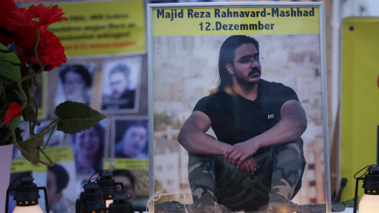 A photograph of Majid Reza Rahnavard stands on a table among candles during a demonstration by supporters of the National Council of Resistance of Iran outside the German Foreign Ministry in Berlin, Germany.