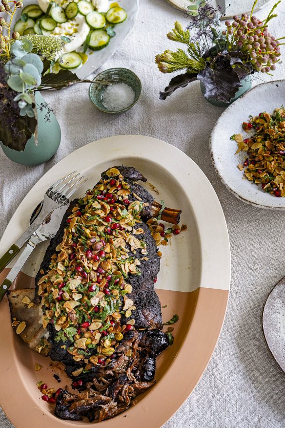 Serve the slow-roasted lamb shoulder with almond and pomegranate crust on top and in a bowl.