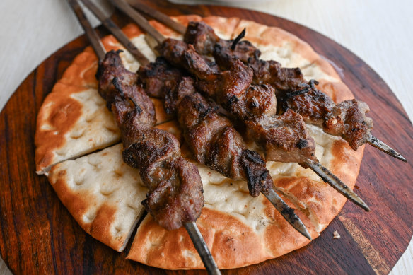 Xinjiang-style lamb skewers over juice-absorbing flatbread.