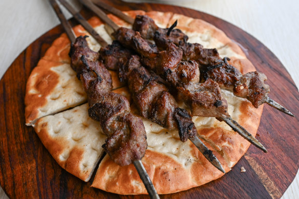 Xinjiang-style lamb skewers over juice-absorbing flatbread.