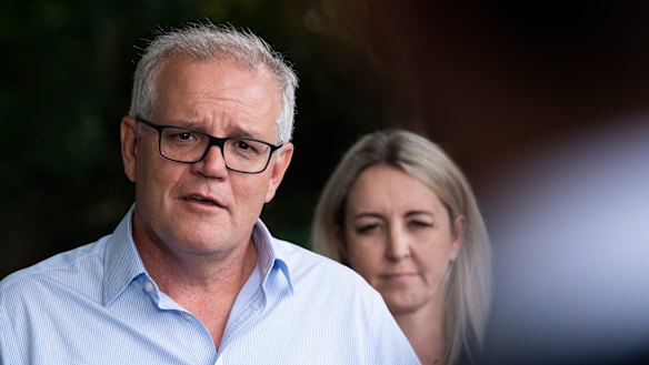 Sarah Richards behind Scott Morrison on Saturday when he addressed media outside Windsor police station, in the flood-raved Hawkesbury area.