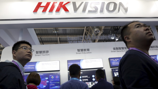Visitors pass by a booth for state-owned surveillance equipment manufacturer Hikvision at the Security China 2018 expo in Beijing. 