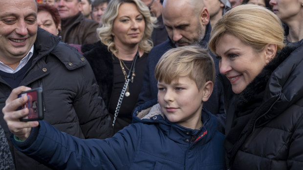 A boy takes a selfie with the Croatian President Kolinda Grabar Kitarovic, right, at a rally near Zagreb on New Year's Eve.