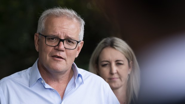 Sarah Richards behind Scott Morrison on Saturday when he addressed media outside Windsor police station, in the flood-raved Hawkesbury area.