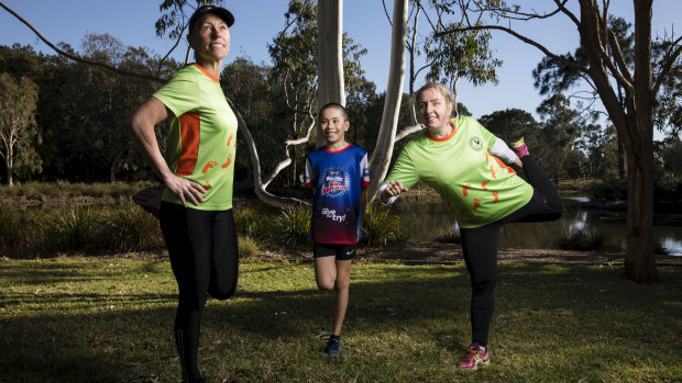 Sue White, Adam Ching and Jeanne-Vida Douglas stretch after running at the Westies Joggers Clubhouse at Mirambeena Reserve in Sydney.