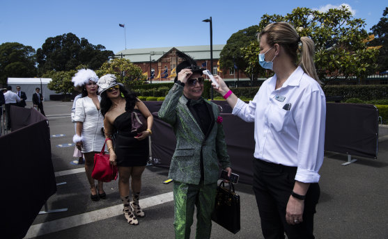 Melbourne Cup Day attendees at Randwick Racecourse having their temperature checked on entry.