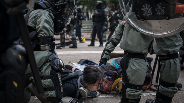 Pro-democracy protesters are arrested by police during clashes after a march in Hong Kong.