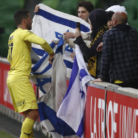 Tomer Hemed of the Phoenix wraps himself in the flag of Israel to celebrate a goal from a penalty during the A-League match between Melbourne City and the Wellington Phoenix.