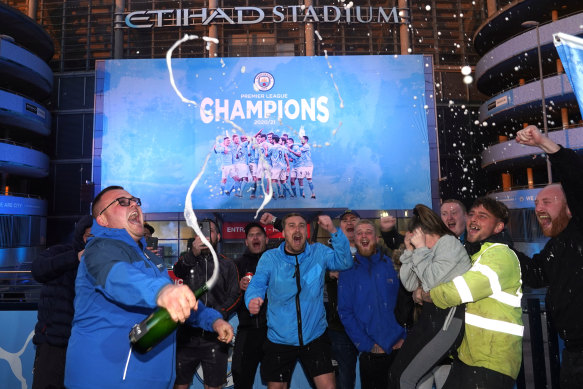 Manchester City fans celebrate the Premier League title outside Etihad Stadium.