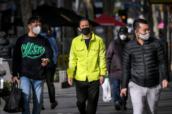 People wear masks in Melbourne in July last year.