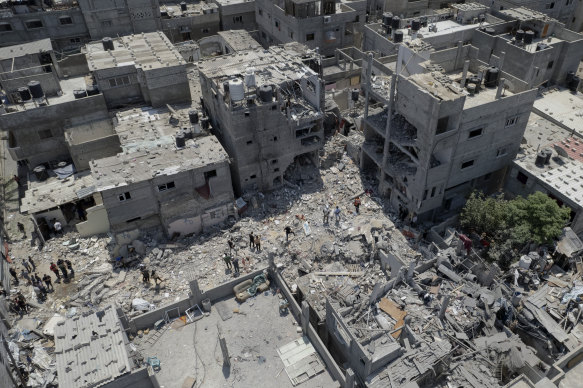 Palestinians search through the rubble of a building in Rafah, southern Gaza Strip where Khaled Mansour, a top Islamic Jihad militant, was killed in an Israeli airstrike.