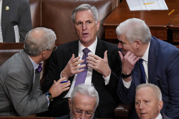 Representatives Patrick McHenry, left, and Tom Emmer, right, huddle with Kevin McCarthy in the House on Thursday (AEDT).