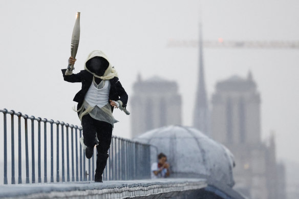 A mysterious torchbearer runs atop the Musee d’Orsay.