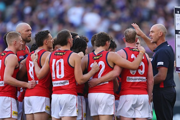 Demons coach Steven King speaks to his players.