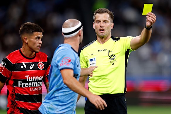 Referee Alex King cautions Sydney’s Ben Garuccio.