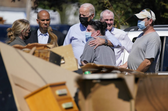 President Joe Biden hugs a person as he tours a neighbourhood impacted by Hurricane Ida.
