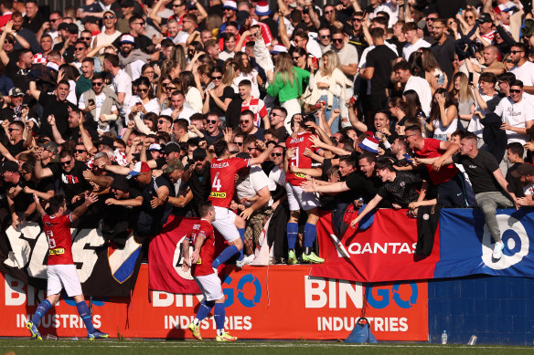 Patrick Antelmi celebrates a goal with Sydney United 58 teammates and fans.