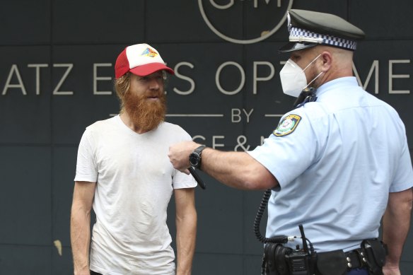 Police speak to organiser Kurt Alchemy after the rally.