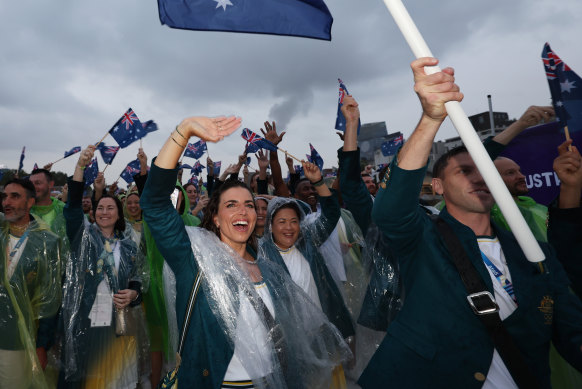 Jessica Fox and Eddie Ockenden, Flagbearers of Team Australia on a boat waving their flag along the River Seine.