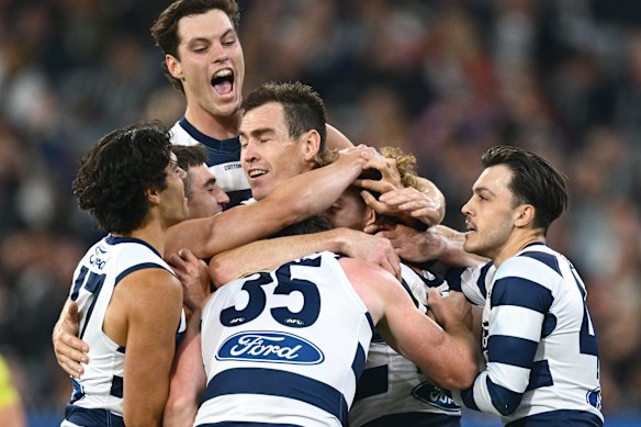Oliver Wiltshire of the Cats is congratulated by teammates after kicking a goal.