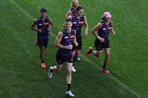 Patrick Voss acknowledges supporters while jogging laps at the Cockburn ARC oval.