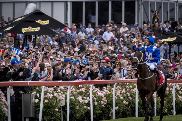 Winx and jockey Hugh Bowman salute the crowd at Moonee Valley in 2018 after winning the Cox Plate for the fourth time.