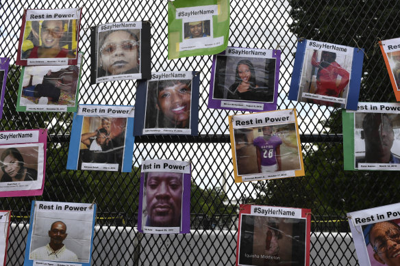 Photos of black victims are displayed on a fence at Black Lives Matter Plaza, Washington. 