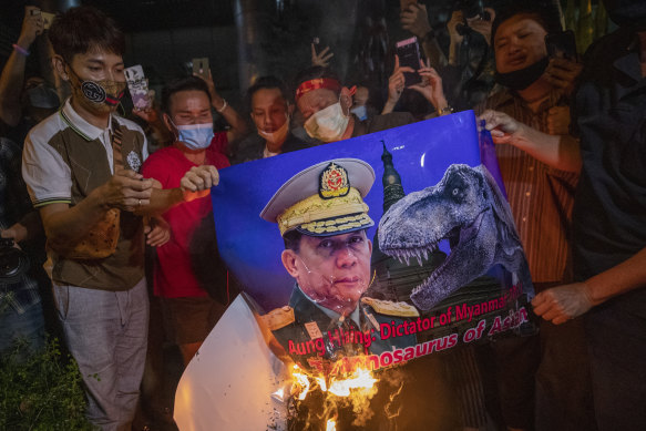 Myanmar nationals living in Thailand set fire to a picture of military leader Min Aung Hlaing during a protest in front of Myanmar embassy in Bangkok.