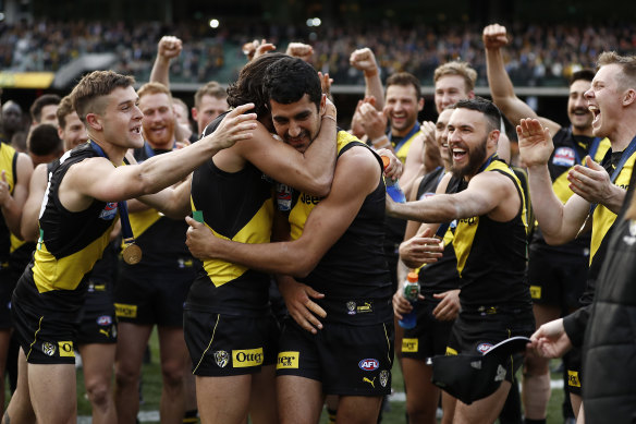 Marlion Pickett is embraced by Tiger teammates after their premiership victory in 2019.