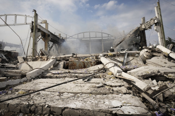 Ukrainian firefighters work in destroyed buildings after a rocket attack in Kharkiv on August 19.