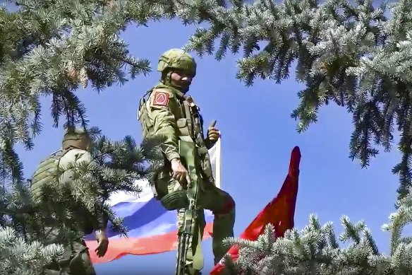 Russian soldiers set a national flag and a replica of the Victory banner after capturing the village of Bilohorivka in Luhansk, eastern Ukraine.
