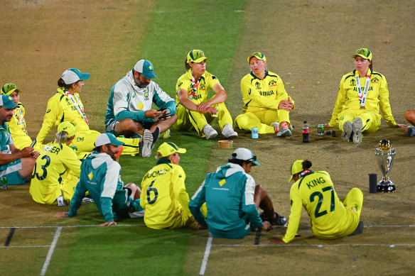 Australia players and coaching staff celebrate on the pitch.