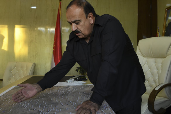 General Nawoz, who oversees the reception area for undocumented refugees at Sehelan, looks over a map of north-eastern Syria.