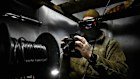 A fighter from the UAV unit of  a regional Striletskyi Special Police Battalion controls a FPV drone from a dugout during combat.