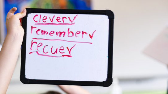 A year one student uses their knowledge of phonics to spell on their whiteboard.