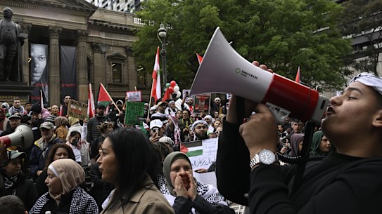 Rally attendees stand in solidarity with Palestine at the Victoria State library during the Melbourne Rally for Palestine.