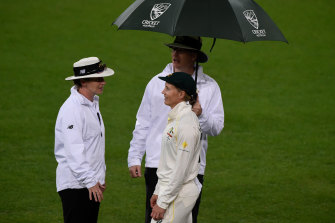 Meg Lanning speaks to the umpires during a break for rain at Metricon Stadium.