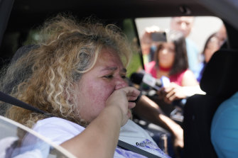 Grace Valencia, great aunt of shooting victim Uziyah Garcia, tries to hold back tears as she talks to the media from a vehicle after picking up a copy of the Texas House investigative committee report on the shootings.