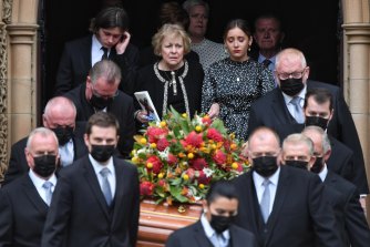 John Fahey's widow, Colleen, flanked by their grandchildren Amber and Campbell as his coffin is carried out of the cathedral. 