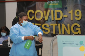 A healthcare worker sanitises her hands before conducting COVID-19 tests at a drive-through testing station in Cape Town, South Africa.
