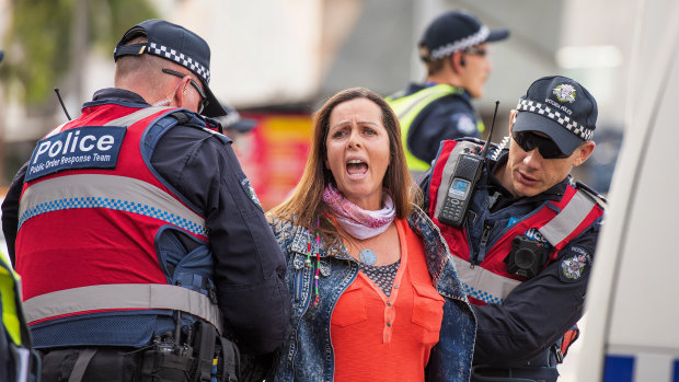 One protester is removed by police on Monday morning.